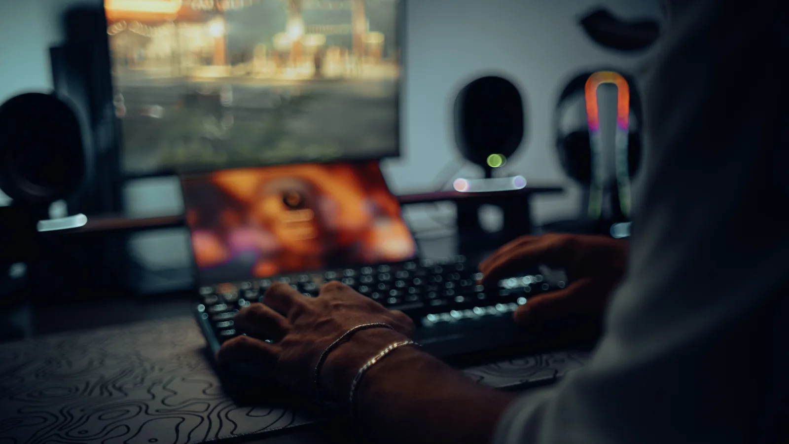 Focused man typing in a dimly lit room, creating a moody atmosphere.