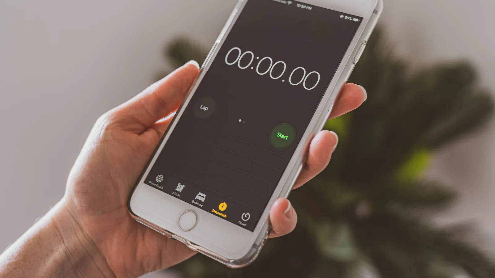 Smartphone held in hand displaying a stopwatch timer app.