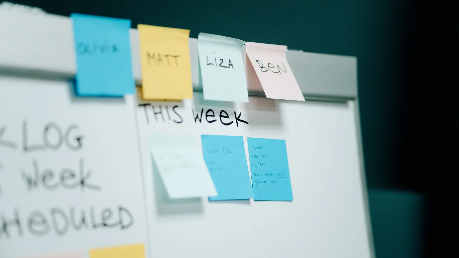 Close-up of a whiteboard with colorful sticky notes for task organization and planning.