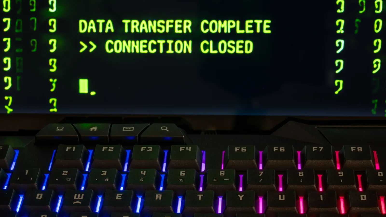 Close-up of a RGB lit keyboard with a screen displaying 'Data Transfer Complete'.